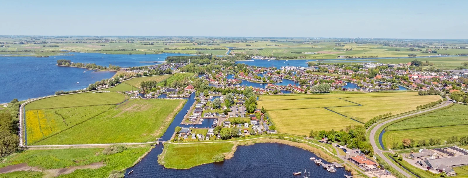Luchtfoto van het Friese merenlandschap met dorp en jachthaven