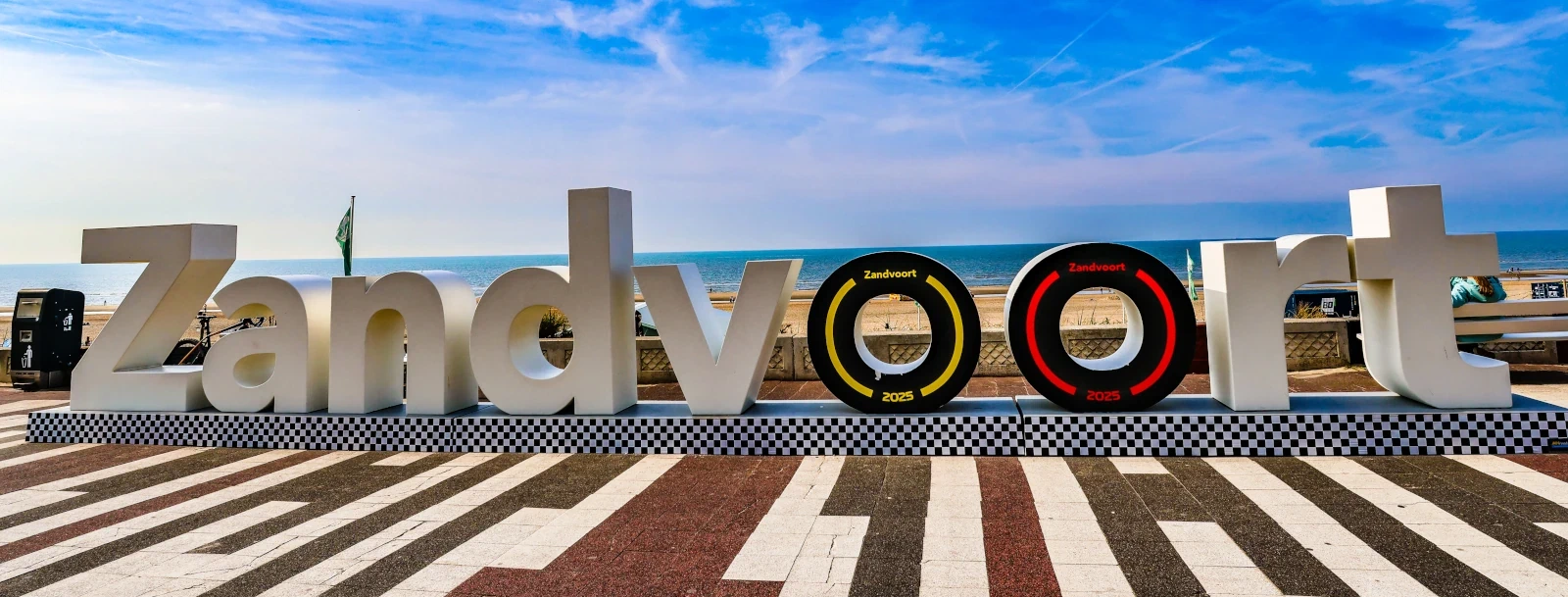Zicht op de kustlijn en het strand van Zandvoort met het iconische bord met de stadsnaam