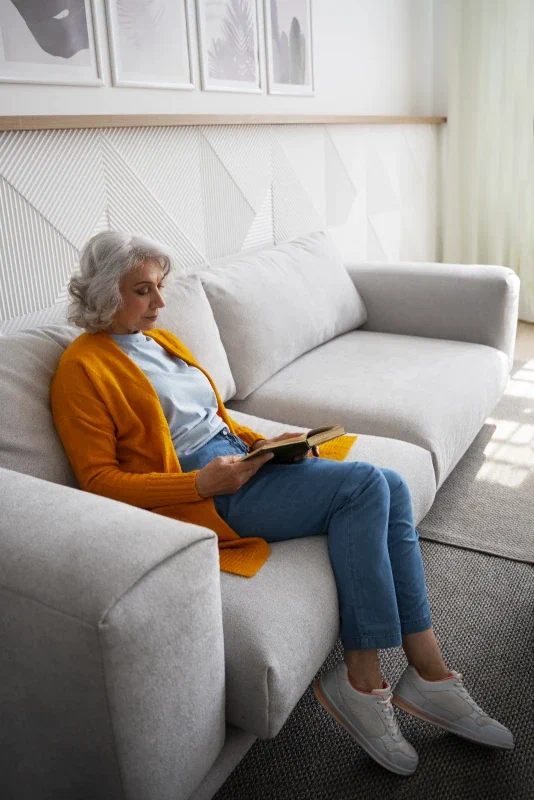 Mevrouw leest een boek in haar woning