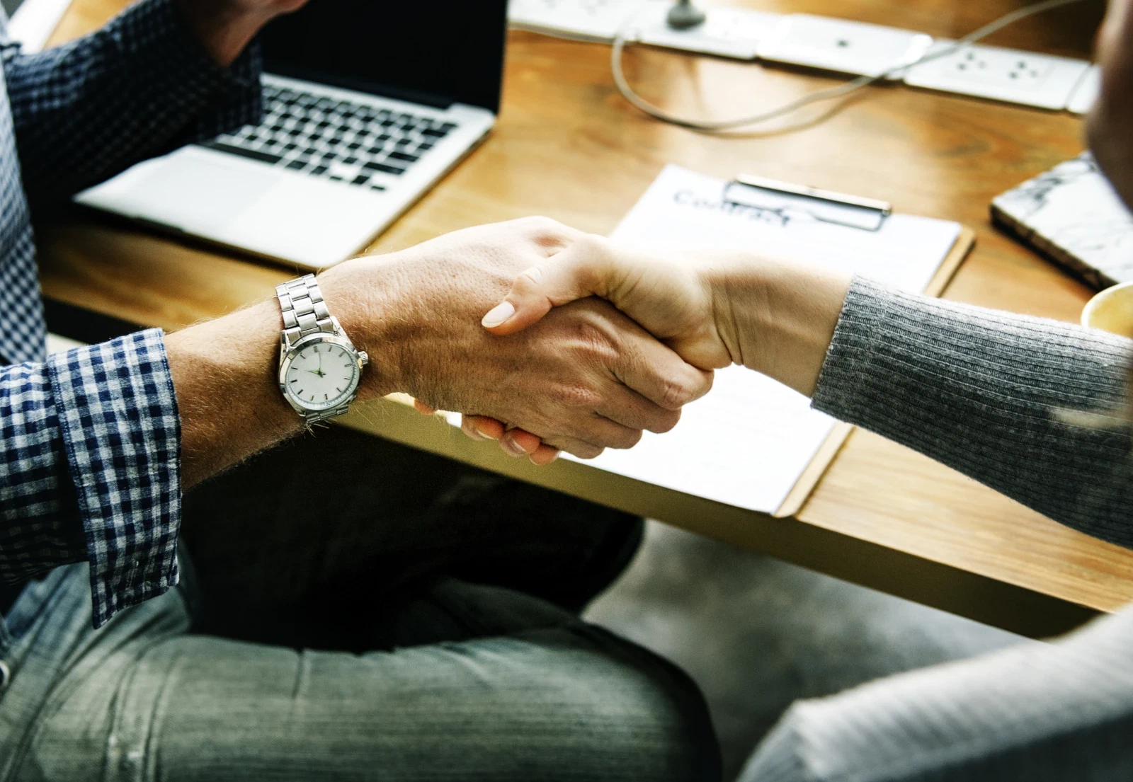 Handdruk boven een contract op een bureau